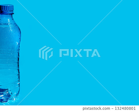 wet plastic bottle of water on blue background wet plastic bottle of water on blue background 132480801