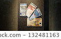 Four euro banknotes on a panel, arranged like playing cards. 132481163