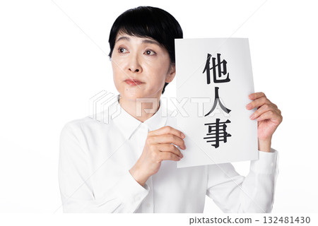 A senior woman pretending not to know anything and holding a piece of paper that says "It's not my business" 132481430