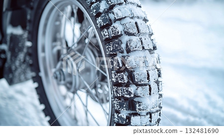 Motorcycle tire covered in snow during winter adventure in a snowy landscape 132481690