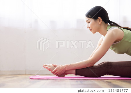 Middle-aged woman stretching on a yoga mat 132481777