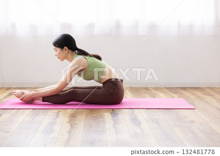 Middle-aged woman stretching on a yoga mat 132481778