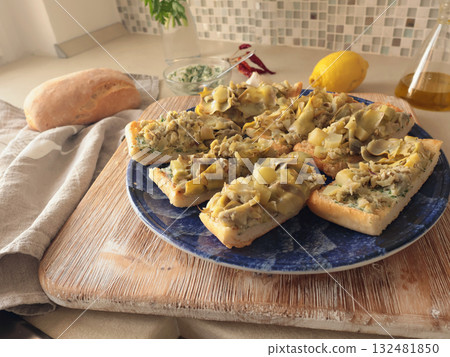 Bruschetta on plate with boiled artichokes. Healthy eating and traditional Italian dish. Fresh, seasonal farm produce. Bruschetta on plate with boiled artichokes. Healthy eating and traditional Italian dish. Fresh, seasonal farm produce. 132481850