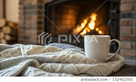 Cozy fireside moment with warm drink on soft blanket for ultimate relaxation vibes 132482503