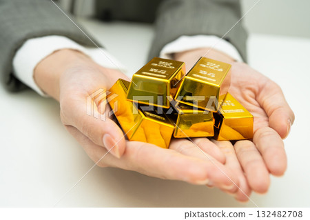 Asian woman holding gold bar in finance business. Asian woman holding gold bar in finance business. 132482708