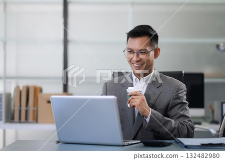 Businessman using laptop computer in office. Happy man, entrepreneur, small business owner working online. 132482980