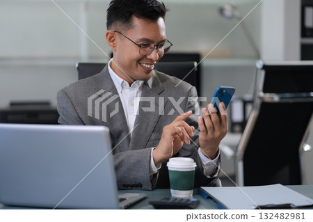 Businessman using mobile phone play social and enjoys a coffee. 132482981