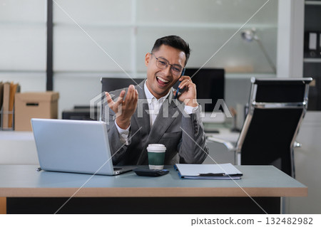 Businessman using laptop computer in office. Happy man, entrepreneur, small business owner working online. Businessman using laptop computer in office. Happy man, entrepreneur, small business owner working online. 132482982