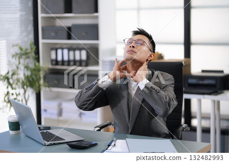 Male businessman is doing a stretchy posture due to sitting in the office for too long, office syndrome concept. 132482993