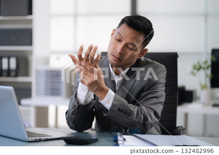 Male businessman is doing a stretchy posture due to sitting in the office for too long, office syndrome concept. Male businessman is doing a stretchy posture due to sitting in the office for too long, office syndrome concept. 132482996