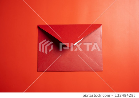Top view of red envelope or postcard on red background. Mockup, blank template, copy space. Greeting or invitation card with flat lay style 132484285