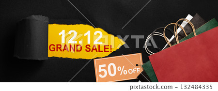 Top view of black ripped paper and text of 12.12 grand sale with up to 50% text on the label tag. Copy space. Flash sale concept 132484335