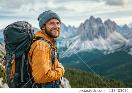 A hiker in an orange jacket and gray beanie smiles while taking in stunning mountain scenery in the Dolomites A hiker in an orange jacket and gray beanie smiles while taking in stunning mountain scenery in the Dolomites 132485011