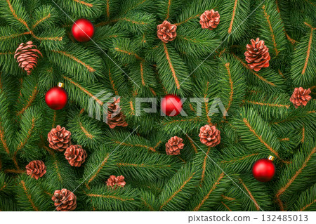 Red ornaments and pine cones decorate lush green evergreen branches for a festive holiday theme 132485013