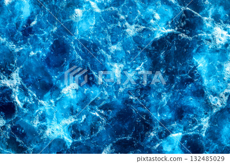 Bright blue water filled with bubbles and waves is seen in the afternoon light, creating a tranquil and inviting underwater scene 132485029