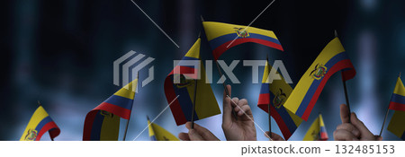 Ecuador flags in their hands on a blurred urban background 132485153