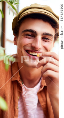 Young man smiling and eating french fries outdoors 132485390