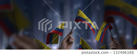 Ecuador flags in their hands on a blurred urban background 132486168