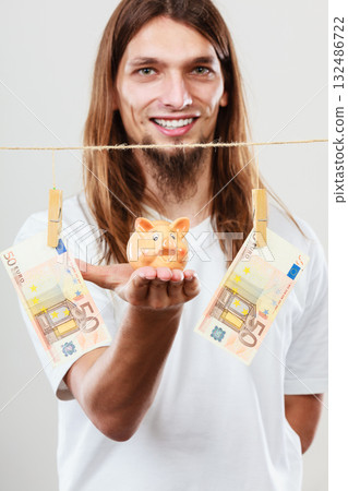 Man holding moneybox piggybank Man holding moneybox piggybank 132486722