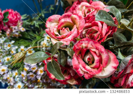 Realistic artificial roses arranged in a vibrant floral display for event decoration. Themes include sustainable weddings, cost-effective design, artificial botanicals, visual realism Realistic artificial roses arranged in a vibrant floral display for event decoration. Themes include sustainable weddings, cost-effective design, artificial botanicals, visual realism 132486853