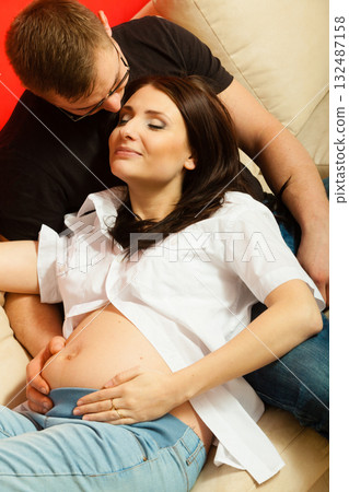 Pregnant woman and man relaxing on sofa 132487158
