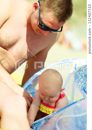 Man playing with little baby on beach Man playing with little baby on beach 132487310