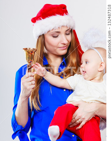 Mother wearing santa hat holding baby 132487318