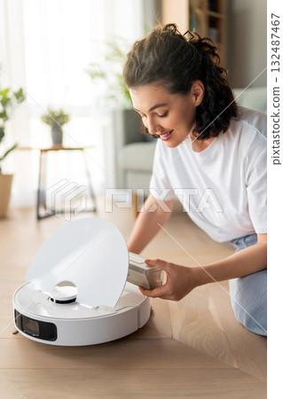White robotic vacuum cleaner on wooden floor 132487467
