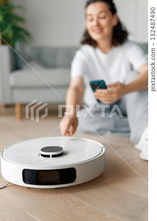 White robotic vacuum cleaner on wooden floor White robotic vacuum cleaner on wooden floor 132487490