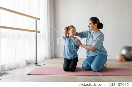 girl doing exercises under doctor's supervision girl doing exercises under doctor's supervision 132487625
