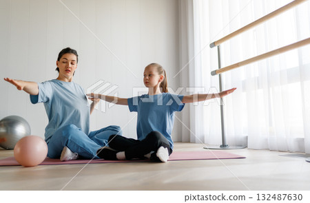 girl doing exercises under doctor's supervision girl doing exercises under doctor's supervision 132487630