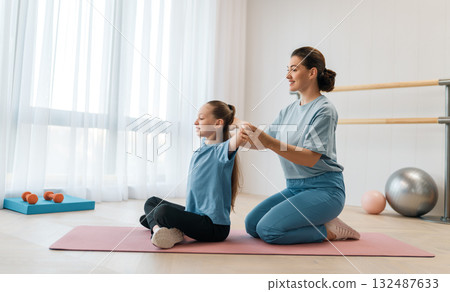 girl doing exercises under doctor's supervision 132487633