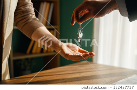 Real estate agent gives house keys to new homeowner Real estate agent gives house keys to new homeowner 132487737