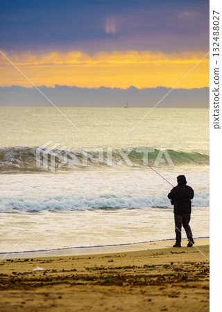 Angler with fishing rod on sea shore Angler with fishing rod on sea shore 132488027
