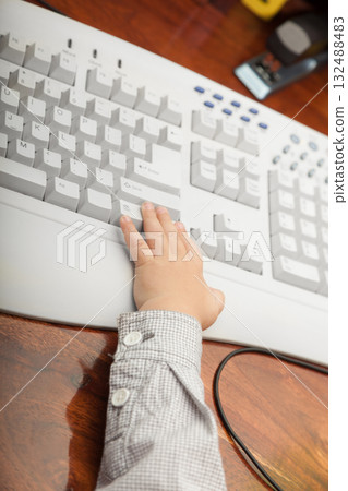 Hand of little boy child kid on the computer keyboard 132488483