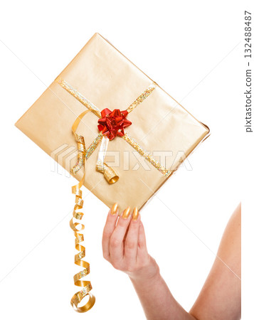 Female hand holding golden gift box isolated Female hand holding golden gift box isolated 132488487