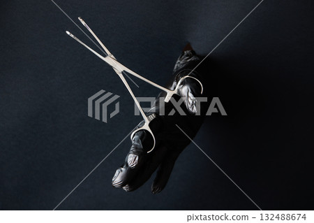 hand-held stainless steel surgical scissors with gloves. 132488674