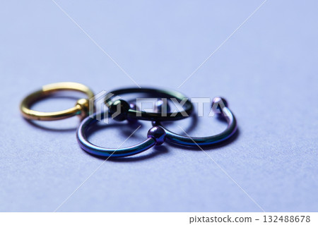 Piercing earrings close-up. On a black background. 132488678