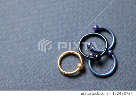 Piercing earrings close-up. On a black background. Piercing earrings close-up. On a black background. 132488724