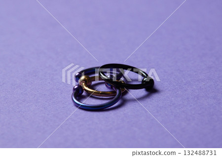 Piercing earrings close-up. On a black background. 132488731