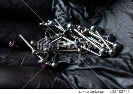 Piercing earrings close-up. On a black background. Piercing earrings close-up. On a black background. 132488745