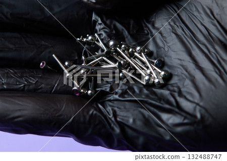 Piercing earrings close-up. On a black background. Piercing earrings close-up. On a black background. 132488747