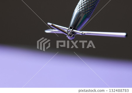 Piercing earrings close-up. On a Violet background. 132488783