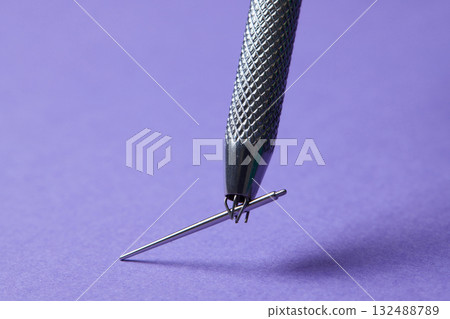 Piercing earrings close-up. On a Violet background. 132488789