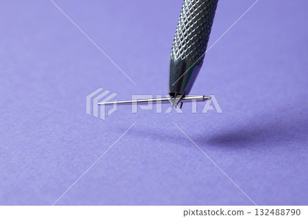 Piercing earrings close-up. On a Violet background. 132488790