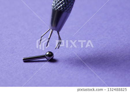 Piercing earrings close-up. On a Violet background. 132488825