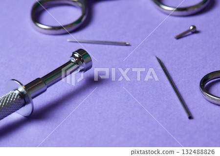 Piercing earrings close-up. On a Violet background. 132488826
