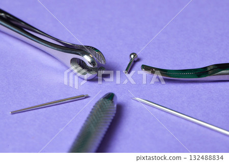 Piercing earrings close-up. On a Violet background. Piercing earrings close-up. On a Violet background. 132488834