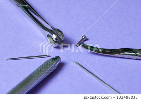 Piercing earrings close-up. On a Violet background. Piercing earrings close-up. On a Violet background. 132488835