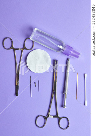 Piercing earrings close-up. On a Violet background. 132488849